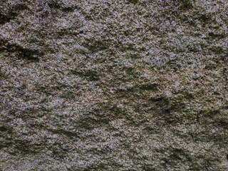 Old, rough, wet stone wall surface background or texture.