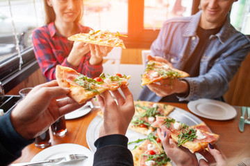 friends of classmates eat pizza in a pizzeria, students at lunch eat fast food