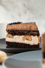 Banana chocolate cake on gray plate on marble background. Selective focus. Vertical photo. Menu for bakery. cafe menu. Pastry. Delicious and sweet dessert at cafe restaurant.