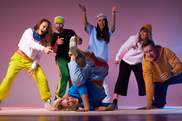 Sportive slim female dancer breakdancing on floor, standing on head, dancing upside down, leaning...
