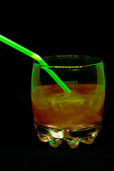 Glitter drink with a cocktail tube close-up isolated on a black background