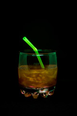 Glitter drink with a cocktail tube close-up isolated on a black background