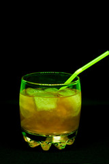 Glitter drink with a cocktail tube close-up isolated on a black background