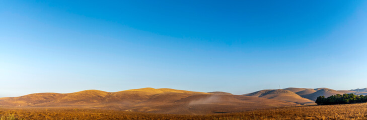 Fototapeta na wymiar Panorama of brown, golden hills 