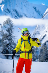 Fototapeta na wymiar Portrait of sportive man in helmet with skis on his shoulder