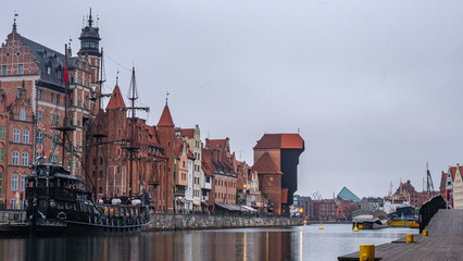 City Gdansk in Poland with the oldest medival port crane called Zuraw and a promenade along the riverbank of Motlawa River. November.