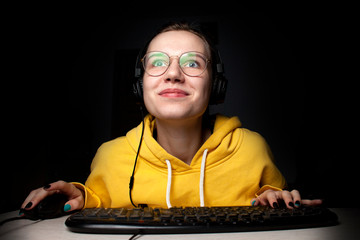 girl gamer sits at a laptop at night at home, a student plays games, she loses and wins