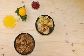 Meat goulash in a dark cup, stewed potato stew and a mug with lemon juice, the basis of diet food, protein diet, close-up, top view, rustic style. Grilled meat with sauce, place for text and recipe,
