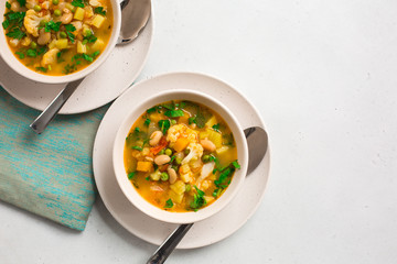 Homemade Italian minestrone - rustic vegetarian soup made with: beans, cauliflowers, onion, celery, carrots, tomatoes, potatoes, zucchini.