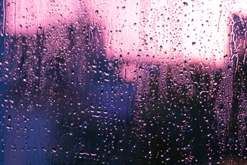 Glass with water drops and colorful blurs