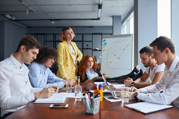 Obraz premium Young caucasian team of business partners coworking in office together, gathered to discuss. Professional occupation concept