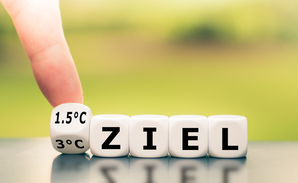 Symbol f&uuml;r das Erreichen des 1,5 Grad Celsius Ziels. Hand dreht einen W&uuml;rfel und &auml;ndert den Ausdruck "3&deg;C Ziel" zu "1,5&deg;C Ziel", oder umgekehrt.