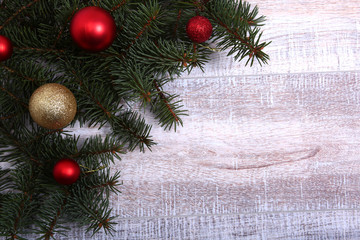 Christmas or New Year background: fur-tree, branches, colored glass balls , decoration and cones on a wooden background
