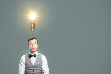 Man looking towards a light bulb above his head