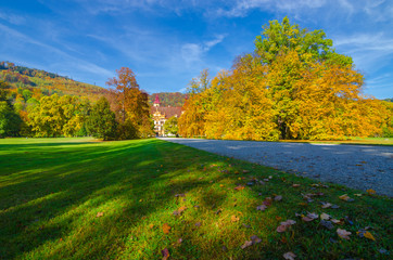 Colorful autumn colors, bright blue sky in the park and Eggenberg Palace in Graz, Styria region, Austria
