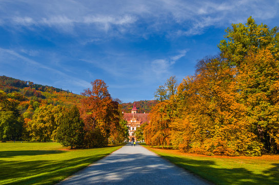 Colorful autumn colors, bright blue sky in the park and Eggenberg Palace in Graz, Styria region, Austria