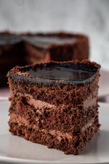 Delicious chocolate cake on plate on table on marble background. Wallpaper for pastry cafe or cafe menu. vertical.