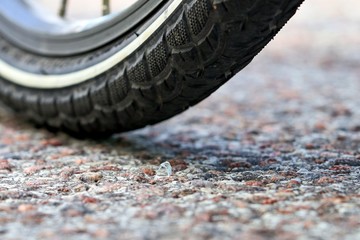 Broken sharp glass on the asphalt. Bicycle wheel.