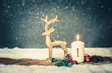 burning candle from 1st advent in front of vintage background and decorative christmas background...