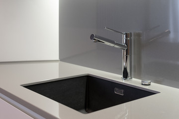 Modern sink with water tap in new contemporary kitchen