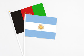 Argentina and Afghanistan stick flags on white background. High quality fabric, miniature national...