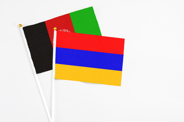 Armenia and Afghanistan stick flags on white background. High quality fabric, miniature national flag. Peaceful global concept.White floor for copy space.