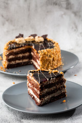 Delicious chocolate cake with white coconut cream on plate on table on marble background. Wallpaper for pastry cafe or cafe menu. vertical.