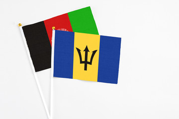 Barbados and Afghanistan stick flags on white background. High quality fabric, miniature national flag. Peaceful global concept.White floor for copy space.