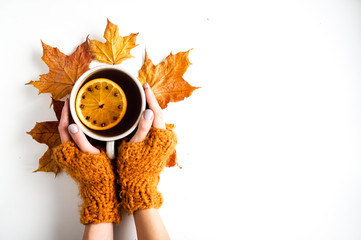 Autumn leaves and cup of tea on white background with copy space. Yellow color, seasonal concept....