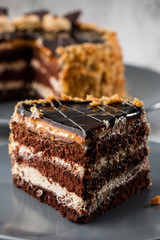 Delicious chocolate cake with white coconut cream on plate on table on marble background. Wallpaper for pastry cafe or cafe menu. vertical.