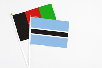 Botswana and Afghanistan stick flags on white background. High quality fabric, miniature national...