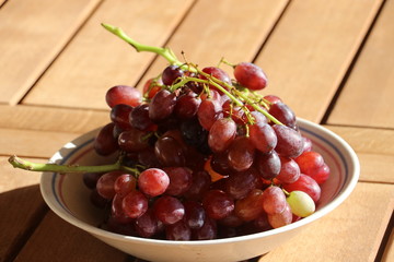 Still life with ripe red grapes from Crete / Greece on wooden table, late autumn harvest. Healthy diet concept.