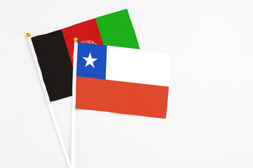 Chile and Afghanistan stick flags on white background. High quality fabric, miniature national flag. Peaceful global concept.White floor for copy space.