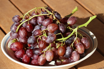 Still lefe with ripe red grapes from Crete / Greece on wooden table, late autumn harvest. Mediterranean Diet concept.