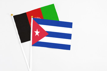 Cuba and Afghanistan stick flags on white background. High quality fabric, miniature national flag....