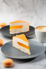 Elegant Cake with coconut, passion fruit, mangoes and bananas, covered with chocolate glaze. Slice of orange layered cake on marble background. Wallpaper for pastry cafe or cafe menu. vertical.