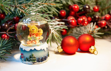 Tło świąteczna z kulą śniegową, gałązkami świerku i czerwonum ozdobami