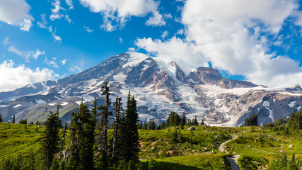 Obraz premium The majestic summit of Mt. Rainier dominates the view in Mt. Rainier National Park. Mt. Rainier is a dormant volcano in the Cascade Mountain Range.