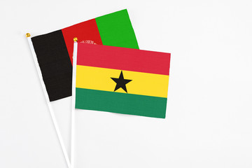 Ghana and Afghanistan stick flags on white background. High quality fabric, miniature national flag. Peaceful global concept.White floor for copy space.
