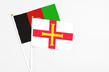 Guernsey and Afghanistan stick flags on white background. High quality fabric, miniature national...
