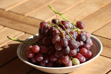 Ripe red grapes from Crete / Greece on wooden table, late autumn harvest