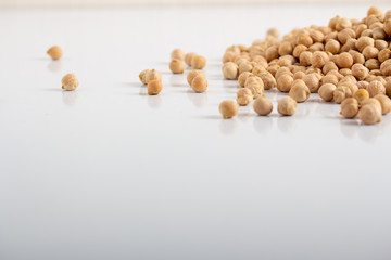 Dried chickpeas scattered on a white background