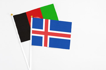 Iceland and Afghanistan stick flags on white background. High quality fabric, miniature national...