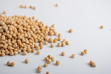 Dried chickpeas scattered on a white background
