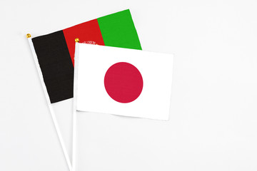 Japan and Afghanistan stick flags on white background. High quality fabric, miniature national...