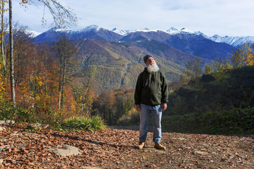 gray-haired ld man with a beard conquers the summit, concept of tourism and recreation in old age