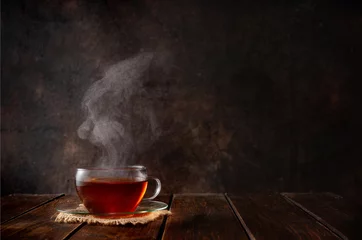  Kop hete thee met stoom op donkere achtergrond © Katecat