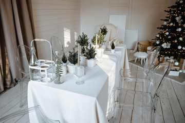 Festive table setting for Christmas. Beautifully decorated dining table with white tablecloth in the living room