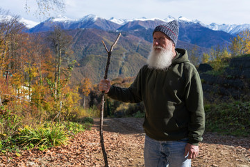 gray-haired ld man with a beard conquers the summit, concept of tourism and recreation in old age