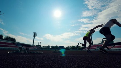Two disabled sportsmen with prosthetic legs start running - Powered by Adobe